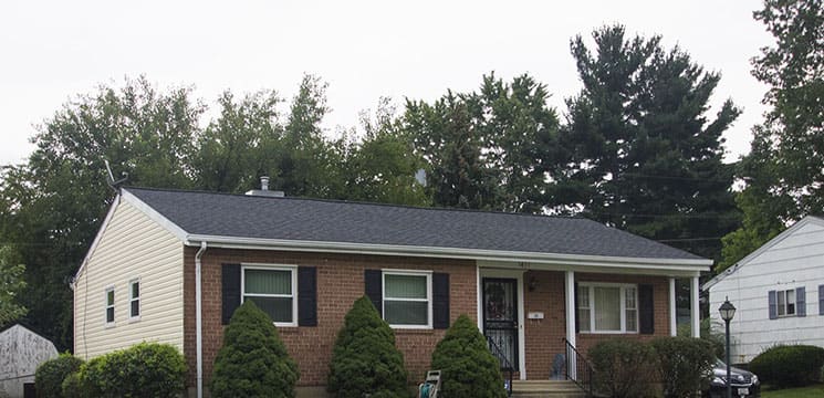longer shot of a small brick house with new roofing